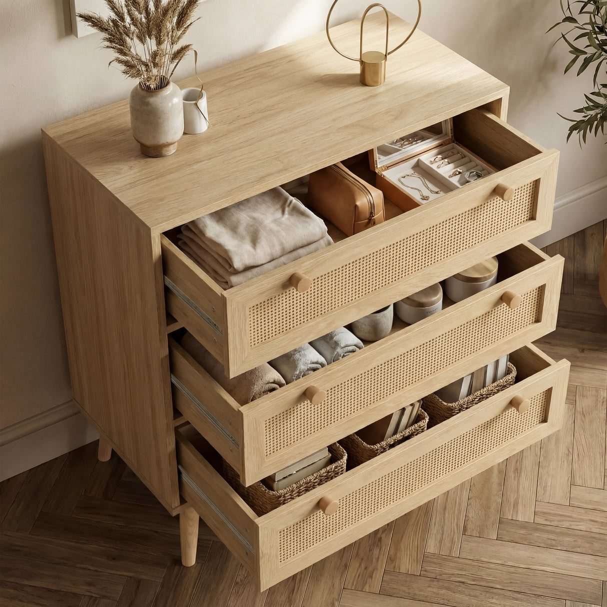 [Oak Effect] Wovena chest of drawers with all four rattan-front drawers open showing folded clothes and accessories inside