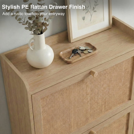 [Oak] Wovena shoe cabinet PE rattan drawer panel close-up with styled top surface showing white ceramic vase, keys tray, and botanical print against white wall