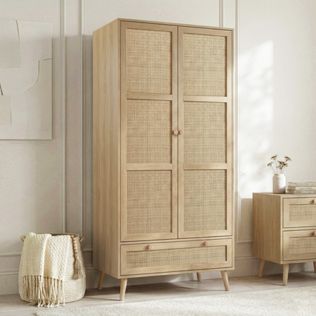 [Oak] Wovena wardrobe three-quarter angle showing rattan door panels and tapered legs in a styled bedroom