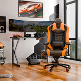 Gaming setup with an orange and black gaming chair, desk, and monitors in a room.