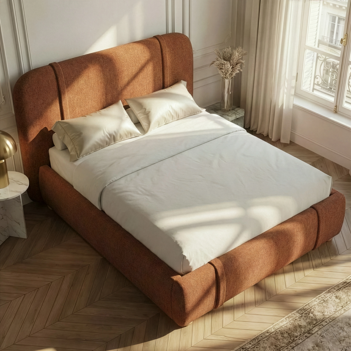 Angled overhead view of warm orange upholstered double bed frame with layered cushions and throw