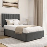 Gray upholstered bed with white bedding and beige blanket in a bedroom setting.