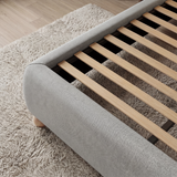 [Double | Grey] Wooden slats inside grey fabric double ottoman bed frame shown from side, above pale cream rug