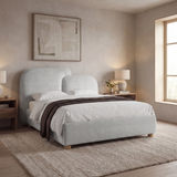 [King | Grey] Side-angle shot grey king ottoman bed frame with draped throw next to woven rug and window