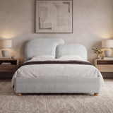 [King | Grey] Front view grey king ottoman bed frame centered between wooden nightstands with warm lamps and wall art