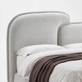 [King | Grey] Close-up grey padded split curved headboard on king ottoman bed frame with pillows and folded throw