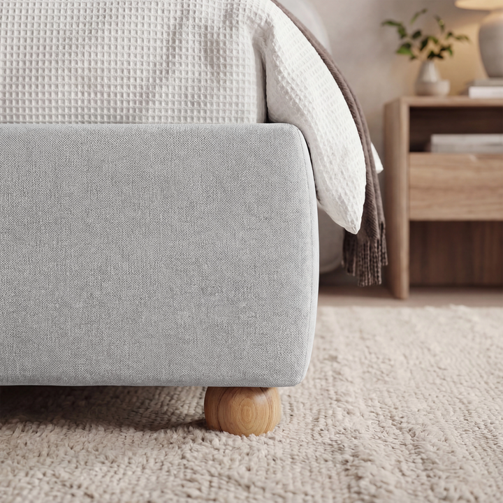 [King | Grey] Wooden slats inside grey fabric king ottoman bed frame shown from side, above pale cream rug