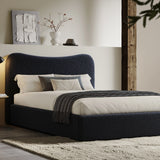 Curved headboard ottoman storage bed in boucle fabric with dark navy finish. Features hidden under-bed storage and modern platform frame design.