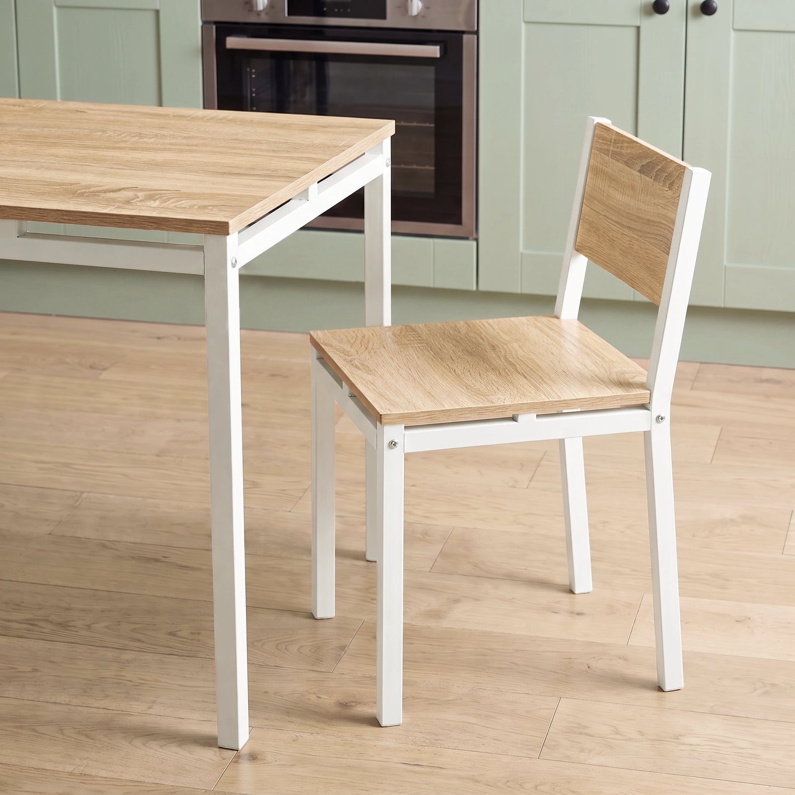 [Pine] Breakfast table edge & chair close-up with wood-effect panels, square grey metal frames, support rails & visible bolts