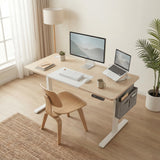 Pine Electric Standing Desk in a bright home office with monitor, laptop stand, and ergonomic chair. Includes side storage and height control panel.