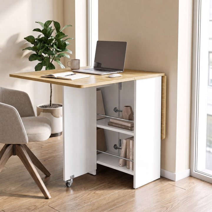 [Pine] Folding dining table for small space used as a desk with one leaf raised, laptop and rod-fronted shelves on wheels.