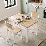 [Pine] Breakfast table and chairs for 2 styled with cereal bowls, coffee mugs and woven placemats in a bright kitchen diner.