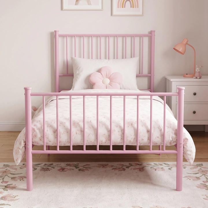 [Pink | Single] Front view showing bar headboard and footboard, floral bedding, a flower cushion, bedside cabinet, and lamp.