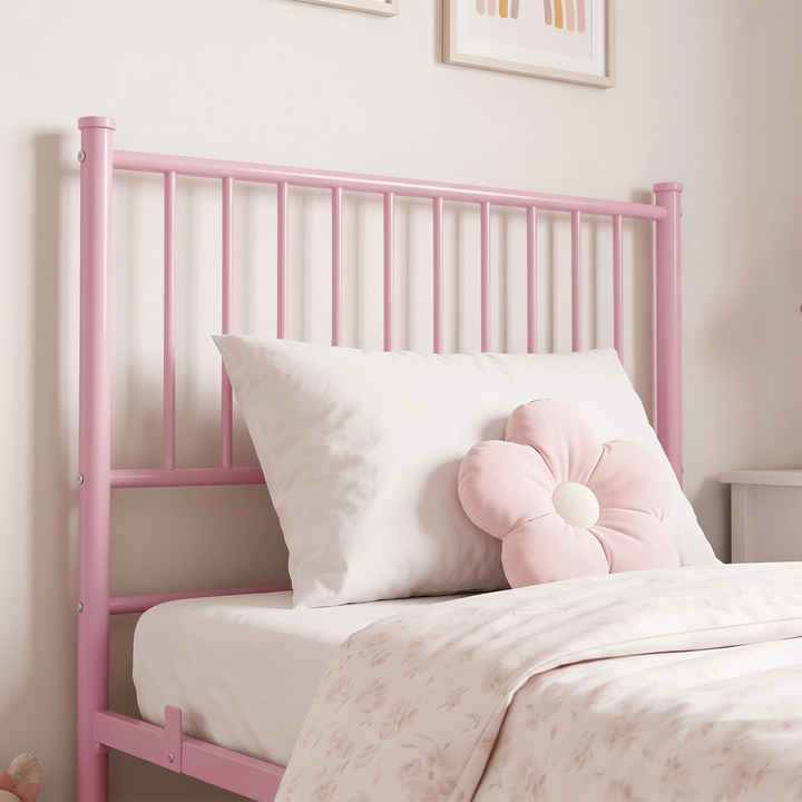 [Pink | Single] Headboard close-up showing vertical bars, capped posts, exposed bolts, a plain pillow, and a flower cushion.