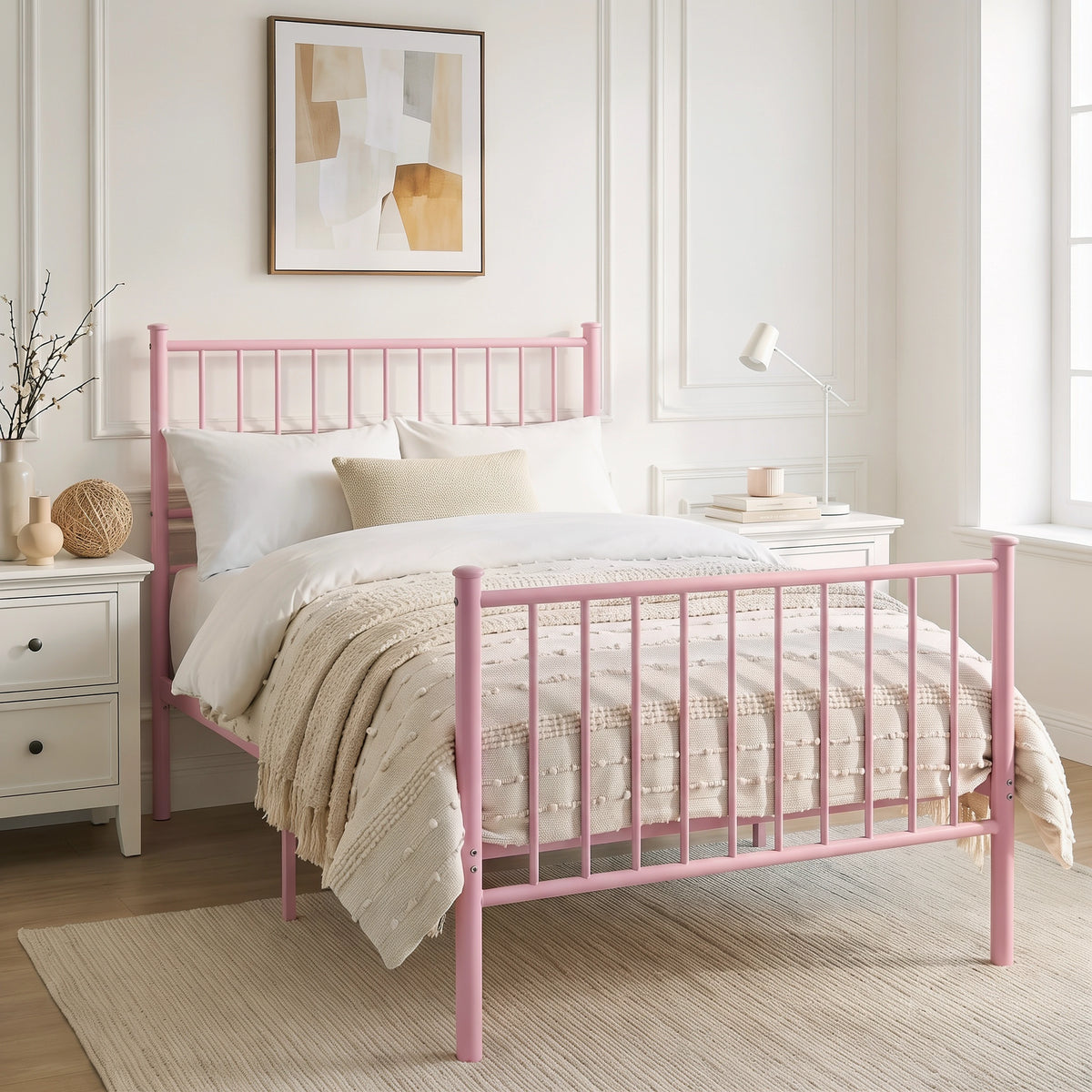 [Pink | Single] Angled view of metal bed with white bedding, beige throw, bar ends, centre leg, nightstand and reading lamp.