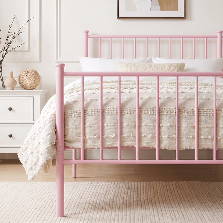 [Pink | Single] Metal bed close up view of bar headboard and footboard, white bedding, beige throw, bedside table & twig vase