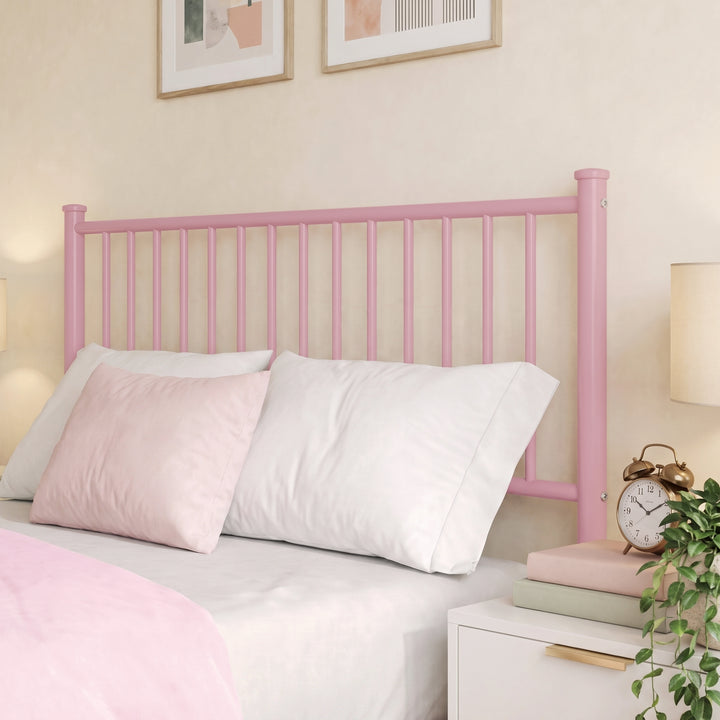 [Pink | Double] Metal double bed close-up of tall pink vertical-bar headboard, pink-white pillows, alarm clock, books & plant