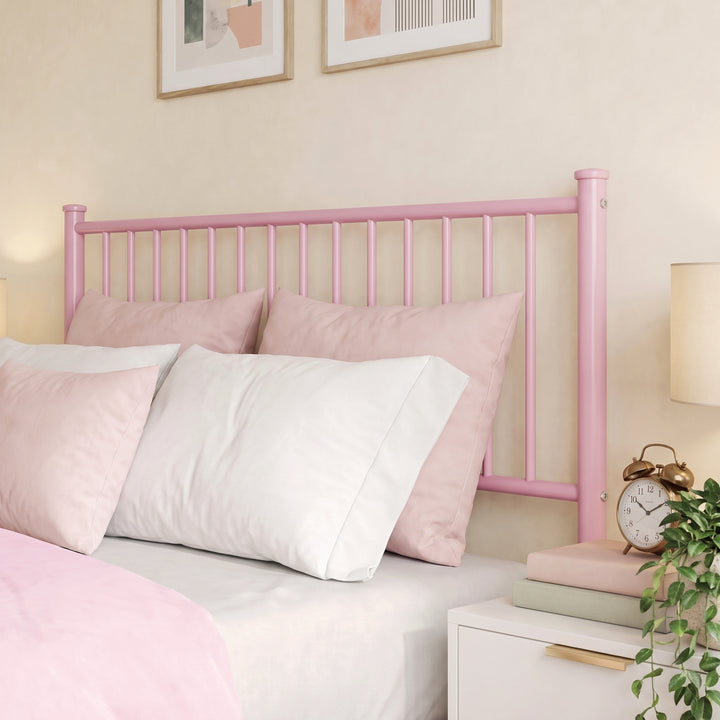 [Pink | Double] Metal double bed close-up of tall pink vertical-bar headboard, pink-white pillows, alarm clock, books & plant
