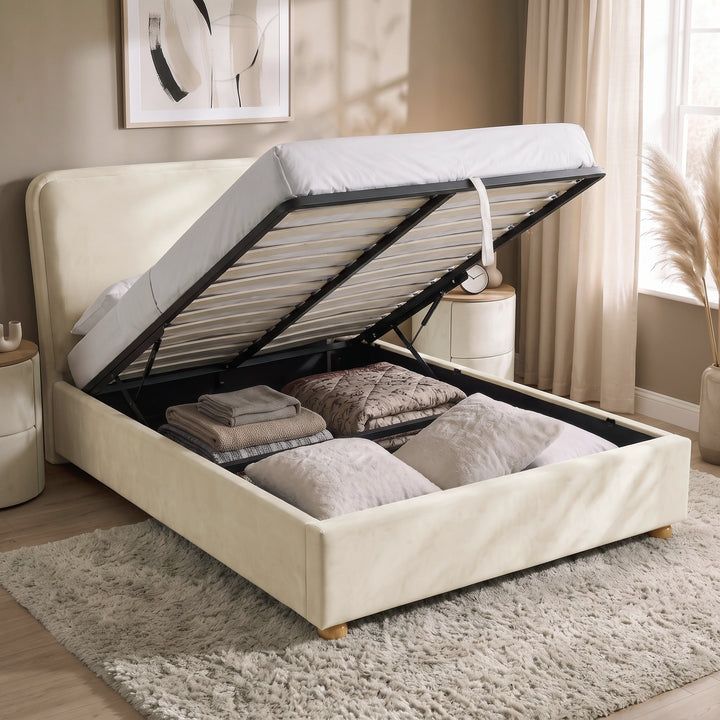 [Double | Beige] Plush velvet Ottoman storage bed open showing gas-lift pistons, wooden slats, pull strap and storage bay