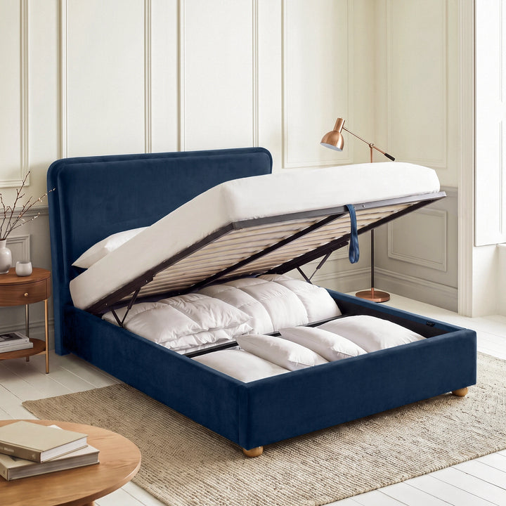 [Double | Blue] Plush velvet Ottoman storage bed open showing gas-lift pistons, wooden slats, pull strap and storage bay