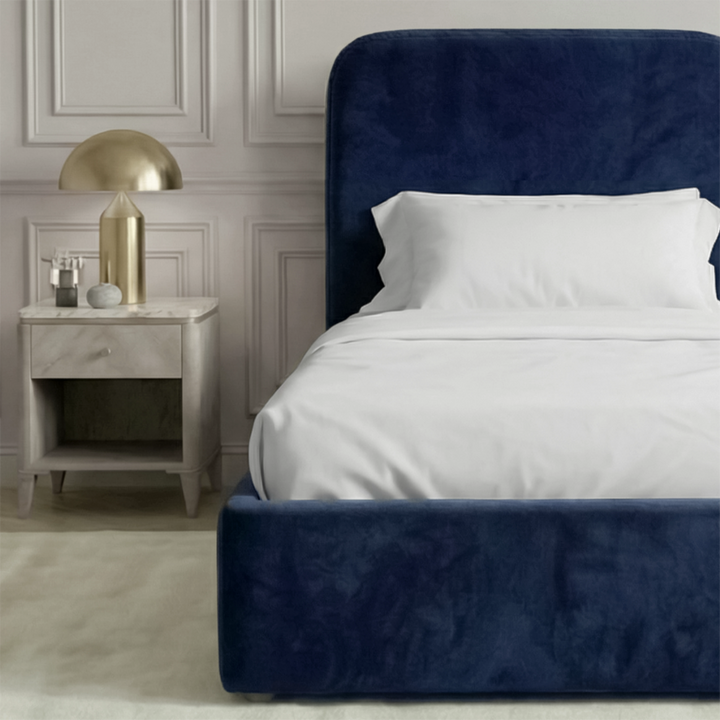 [Single | Blue] Side angle of Pluva ottoman bed showing curved headboard profile and clean velvet base beside nightstand