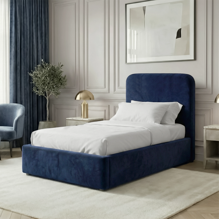 [Single | Blue] Velvet Pluva bed in bedroom with olive tree in vase, brass nightstand lamp and upholstered armchair
