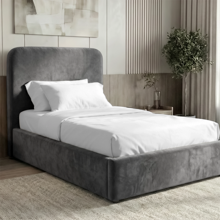 [Single | Grey] Three-quarter view of Pluva velvet bed with smooth rounded headboard and clean upholstered base