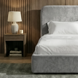 [Single | Light Grey] Head-on shot of Pluva velvet bed with curved headboard symmetric between two lit bedside lamps