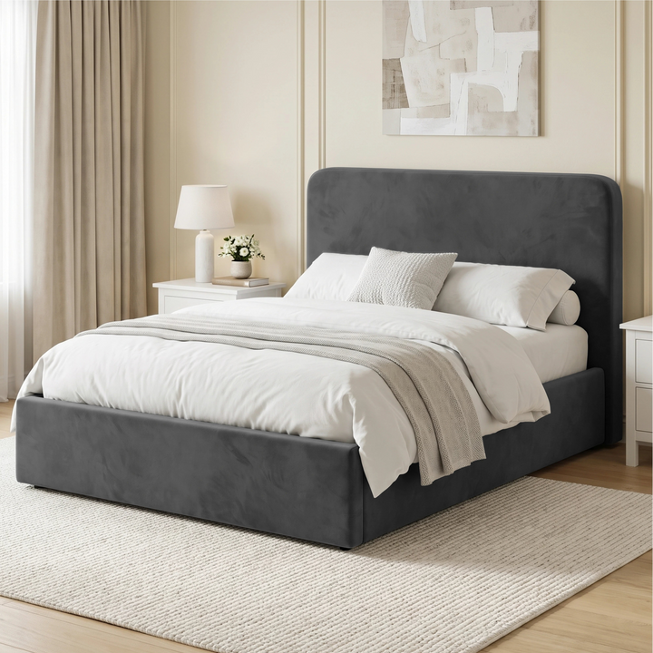 [Double | Grey] Angled bedroom view with rounded upholstered headboard, white bedding, curtain, rug and bedside table