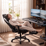 [Black + White] A woman relaxing on the reclined Ergonomic Gaming Chair with Footrest extended.