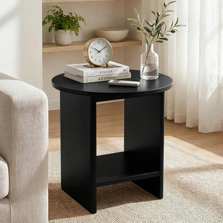 [Black] Living room scene with black round end table, olive branch vase on shelf behind, armchair at left