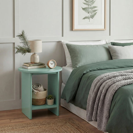 [Sage Green] Sage green round side table styled as nightstand against panelled wall with framed botanical print