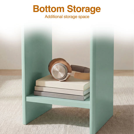 [Sage Green] Close-up of sage green round end table lower shelf with leather over-ear headphones and books