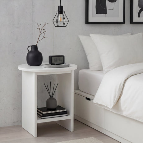 [White] Round white end table beside white duvet bed with geometric pendant lamp hanging overhead