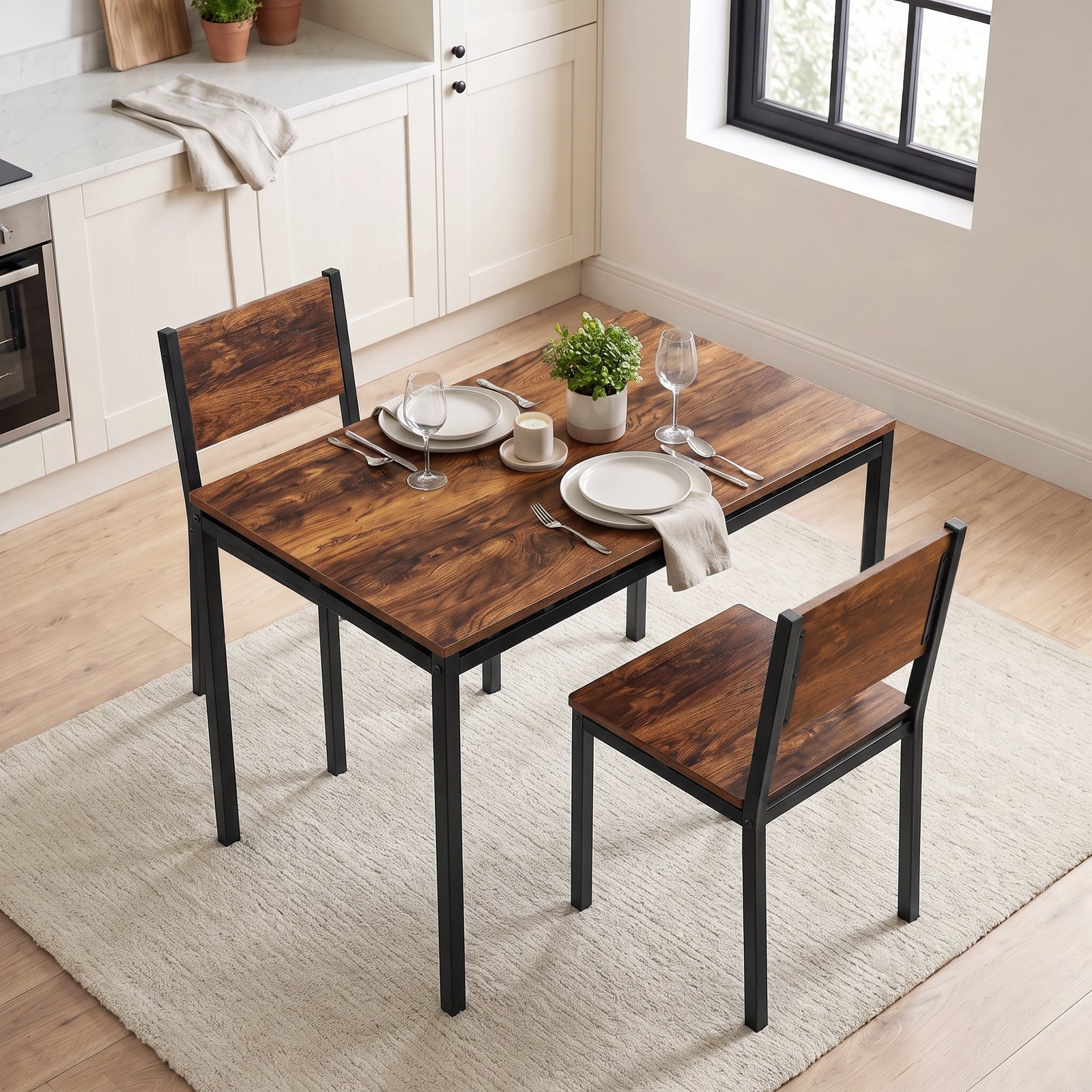 [Rustic] Breakfast table and chairs for 2 styled with plates, wine glasses, cutlery, candle & potted plant in a kitchen diner