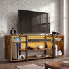 [Rustic] Industrial LED TV Stand with Storage against a white brick wall with amber LED underlighting, open shelves holding a console, VR headset and game cases