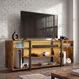 [Rustic] Industrial LED TV Stand with Storage against a white brick wall with amber LED underlighting, open shelves holding a console, VR headset and game cases