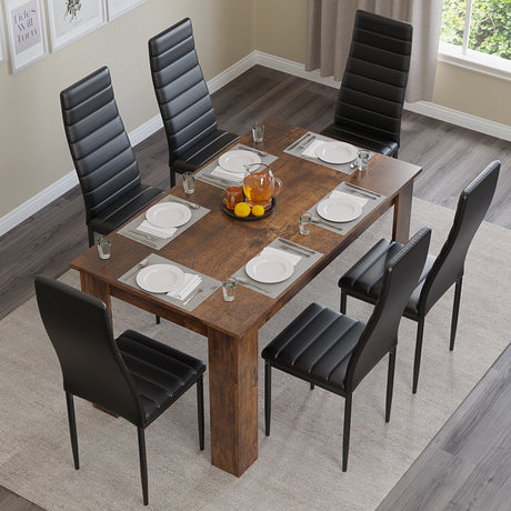 top-down view of dining table and 6 chairs with black upholstery, six plates arranged neatly for a dinner setup