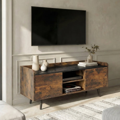[Rustic | 112 cm] Larvik styled at an angle in a warm plastered room with wall-mounted TV, ceramic jug, vases, and books on dark top