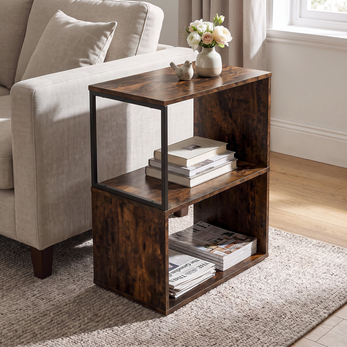 [Rustic] This narrow side table stands beside a sofa with flowers, books and magazines on its open shelves.