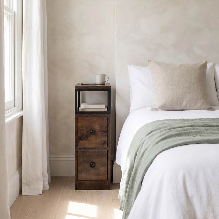 [Rustic] Narrow side table with storage beside a bed, holding a lamp and small bedroom essentials