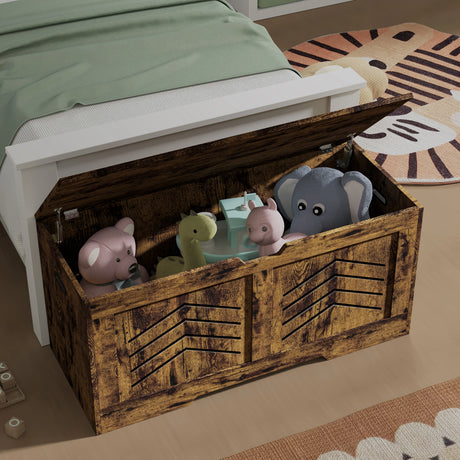 Wooden toy chest with stuffed animals inside, placed on a bed with green bedding.