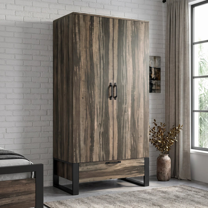 [Rustic Dark Wood] Rustvale wardrobe in bedroom with closed doors, lower drawer, black metal legs, pendant light, bed, and plant.