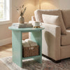 [Sage Green] Small Round Side Table with Shelf Living Room positioned beside a cream sofa with books and mug on top and wicker basket on lower shelf