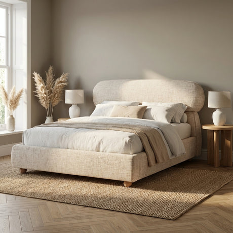 [Double | Beige] Upholstered bed frame showing curved headboard profile and low padded base on herringbone floor