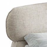 [King | Camel] Close view of headboard curved upper edge showing soft padded profile and woven fabric texture