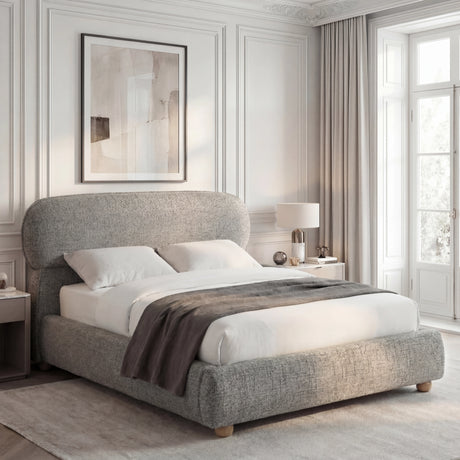 [King | Grey] Side angle of upholstered bed with pill-shaped padded headboard and low-profile footboard on wooden ball feet