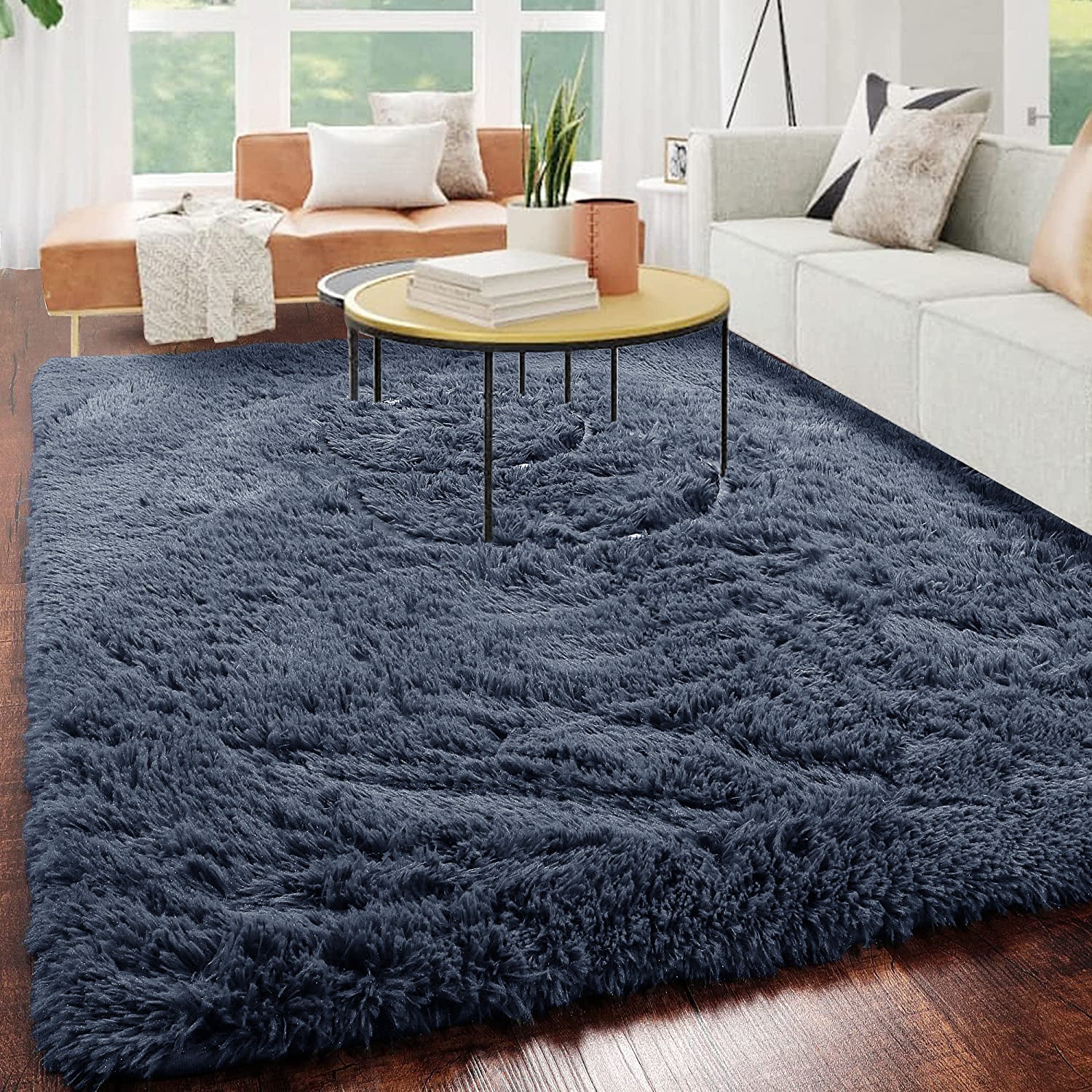 Luxurious shaggy rug in deep blue for a cozy living room with modern sofa and round table