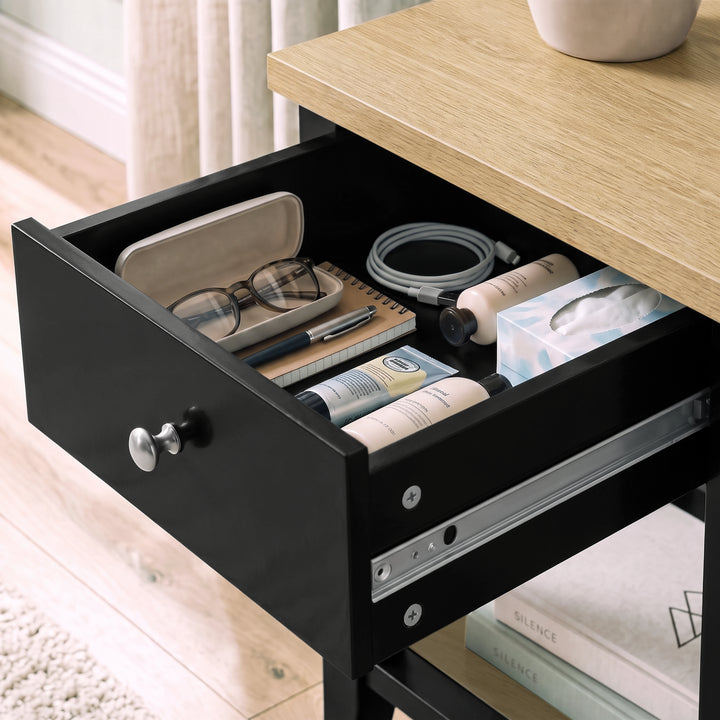 [Black] Close-up of the open drawer holding glasses, books and small bedside essentials