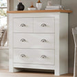 [White] Shaker chest of drawers angled by bedroom window, oak top with vases, silver cup handles, white frame